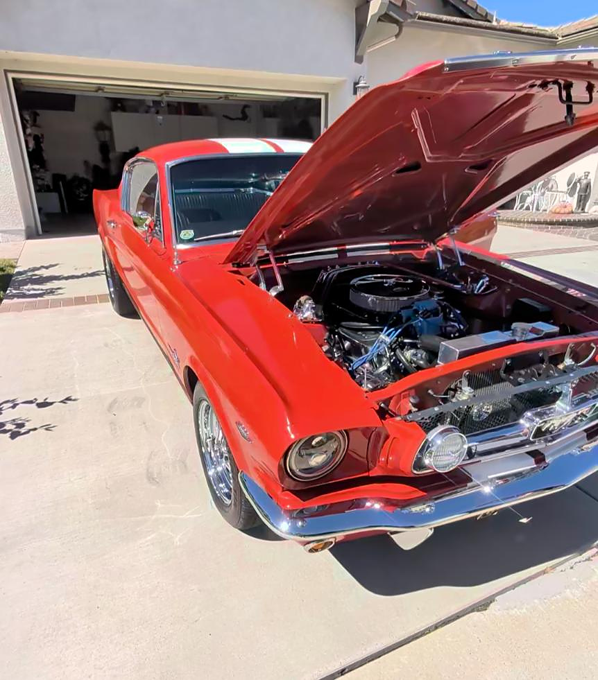 Red classic Mustang with the hood open after a detail